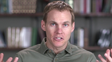 David Platt speaks in front of a library bookshelf.